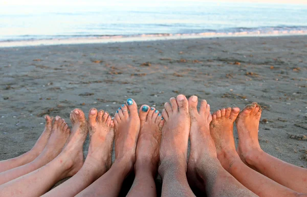 Voeten van een familie in de badplaats op het zee-strand — Stockfoto