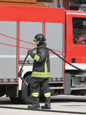 İtalyan itfaiye teşkilatının itfaiyecisi yangını söndürmek için hortumla manevra yapıyordu.