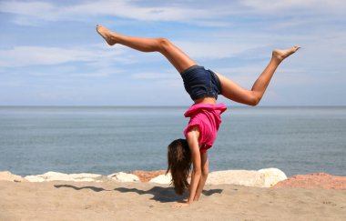Kızlar yaz aylarında deniz kenarında yürüyüş denilen ritmik jimnastik yapıyorlar.
