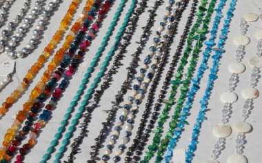 el yapımı ürünlerin tezgahında satılık deriden yapılmış bir sürü kolye var.