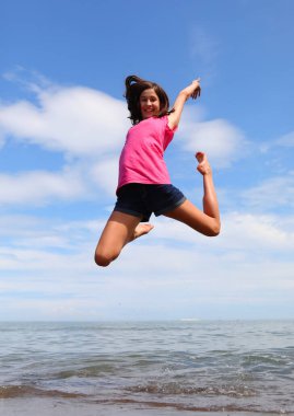 Genç gülümseyen kız mutluluğun ve deniz kıyısında iyimserliğin bir sembolünü oluşturuyor.