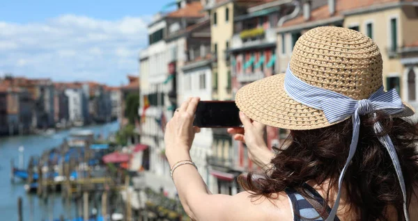 リアルト橋近くの晴れた日にイタリアのヴェネツィア島で携帯電話で写真を撮る女性 — ストック写真