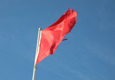 Tehlike sembolü Geniş Kırmızı Bayrak ve arkadaki mavi gökyüzü