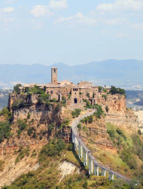 İtalya 'nın orta kesimindeki tepenin üzerindeki CIVITA DI BAGNOREGIO adlı küçük köy manzarası ve logn köprüsü