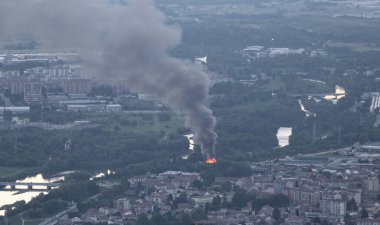 Akşamları nehir kenarındaki şehirde yangın ve siyah yoğun duman