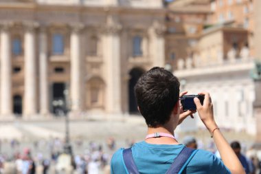 Kameralı genç çocuk yazın Roma ve Vatikan 'da fotoğraf çekiyor.