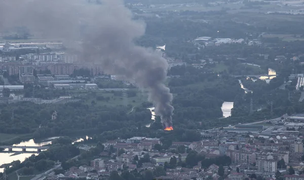 Akşamları nehir kenarındaki şehirde yangın ve siyah yoğun duman