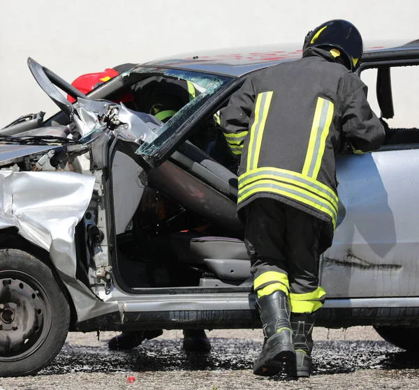 İtfaiyeciler ve otoyoldaki kazadan sonra bozulan araba.