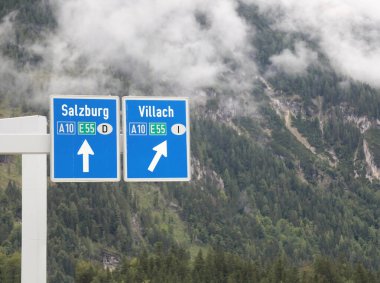 Avusturya ve İtalya sınırındaki yol kavşağında Salzburg ve Villach şehirleri ve otoyolların adı yazılı.