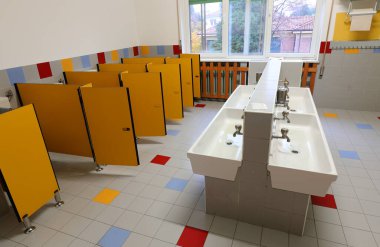 İçinde düşük seramik lavabo ve çocuksuz sarı tuvalet bölmeleri olan bebek odası odaları.