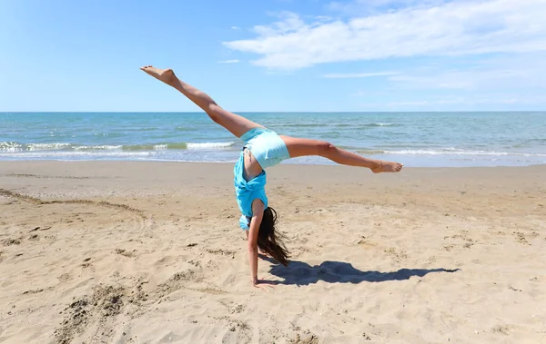 Meisje Met Doet Gymnastiek Met Haar Hoofd Naar Beneden Zee — Stockfoto