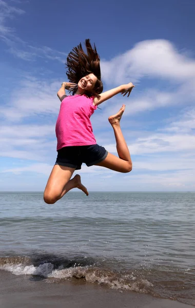 Młoda Dziewczyna Robi Skok Radości Nad Brzegiem Morza Plaży — Zdjęcie stockowe