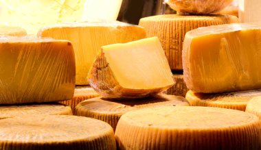 Yiyecek ürünlerinin tazeliğini sağlamak için marketteki mandıra tezgahında selofanla satılan yıllanmış peynir.