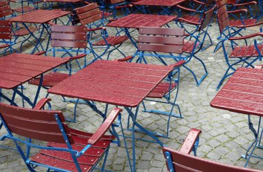 Yağmurdan sonra yağmursuz kafenin ıslak sandalyeleri ve masaları.