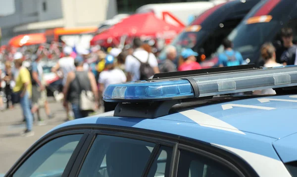 Eskort ve gösteri sırasında üzerinde parlayan ışıklar olan bir polis arabası.