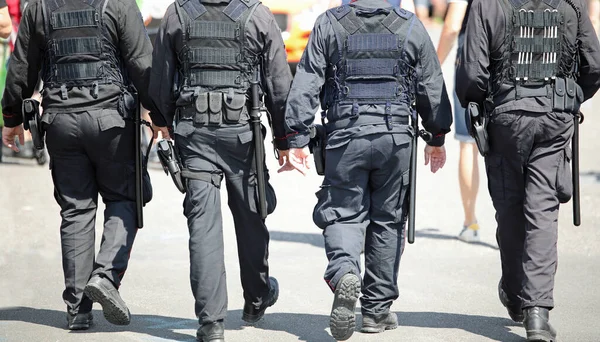 Fyra Poliser Med Vapen Och Skottsäkra Västar Samtidigt Som Patrullerar — Stockfoto