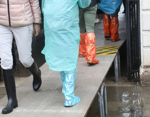 legs of pedestrians over the elevated walkway during a terrible flood in the island of Venice in Italy