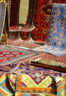 Pazarda satılmak üzere pamuk ve yün halılardan yapılmış pek çok güzel doğu halısı var.