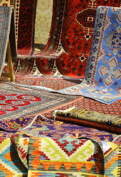 Pazarda satılmak üzere pamuk ve yün halılardan yapılmış pek çok güzel doğu halısı var.