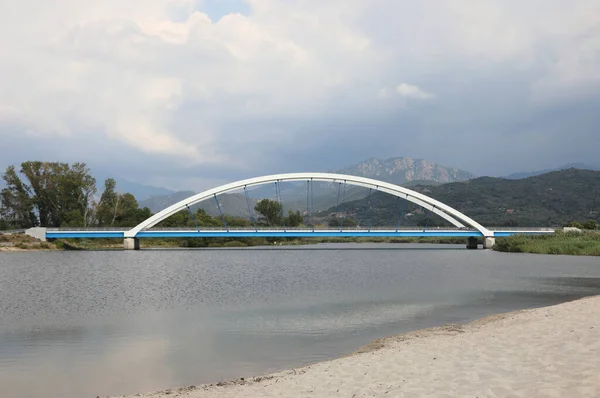 口の近くの川を渡るアーチと鋼のロープで作られた現代の橋 — ストック写真