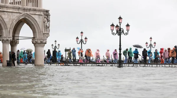 Lidé Dešťovou Výstrojí Kráčející Vyvýšeném Chodníku Ponořeném Náměstí Svatého Marka — Stock fotografie
