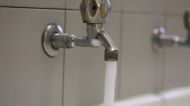 Atıkları önlemek için lavabodaki musluğu kapatırken el.