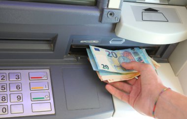 Hand of Man takes european banknotes in the ATM machine