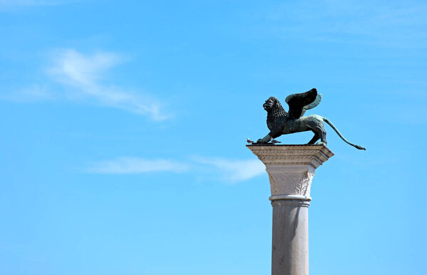 column with statue of Winged Lion in Venice Island in Italy in Europe and blue sky