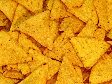 background of yellow tortilla chips made with corn vegetables oils