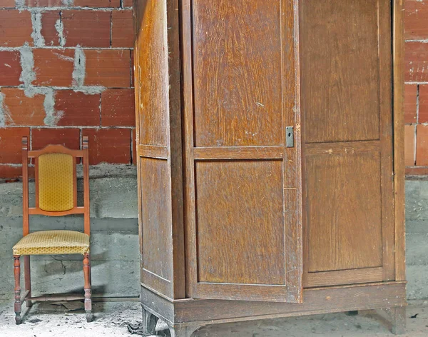有一个旧衣橱和一把旧椅子的阴暗的阁楼 — 图库照片