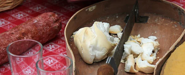 桌上放面包和腊肠的古老的切菜板是农民午餐的主要原料 — 图库照片