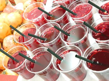 Satılık organik nar suyuyla birlikte plastik bardaklar.