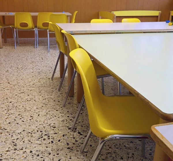 子供も教師もいない小さな黄色の椅子とテーブルのある学校の教室 — ストック写真