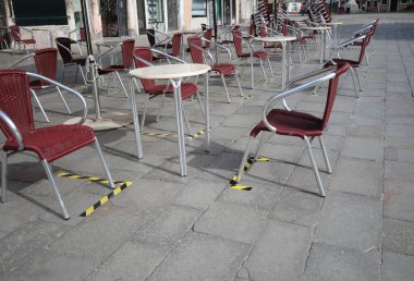Yerdeki tabela ve sandalyeler koronavirüs kilitlenmesi sırasında güvenli bir sosyal mesafeyi korumak için.
