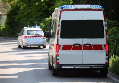Acil durum sırasında trafik kazasından sonra yaralılara yardım etmek için yolda sirenler çalan ve önünde tıbbi bir araç bulunan ambulans minibüsü.