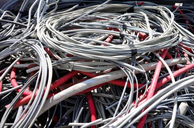 COPPER gibi geri dönüşümlü materyallerin kurtarılması için çöp sahasına düşük voltajlı akım taşımak üzere izole kablolar yığını