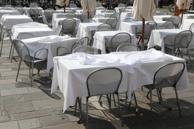 Ekonomik kriz nedeniyle Avrupa şehir meydanında beyaz masa örtüsü ve boş sandalyeli küçük masalar