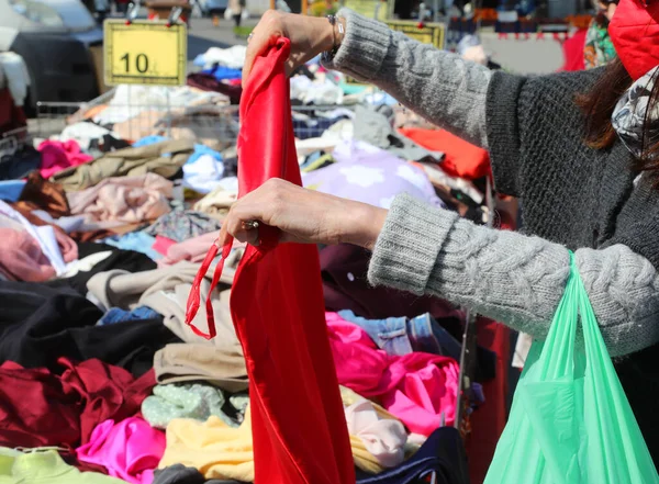 在街上的服装店里挑选衣服的年轻女人的手 — 图库照片