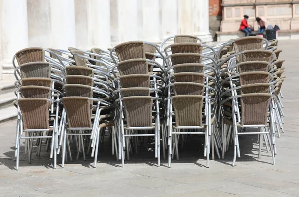 ヨーロッパの都市のコロナウイルスによって引き起こされた恐ろしいロックダウンの間に閉じられたバーに積み上げられた多くの椅子 — ストック写真
