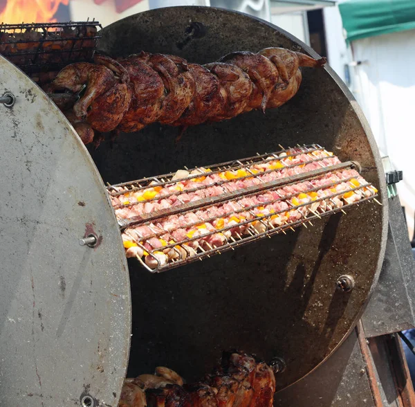 村祭りのレストランで料理をしながら 串焼きの鶏や肉や野菜の串焼きの産業ロティスリー — ストック写真