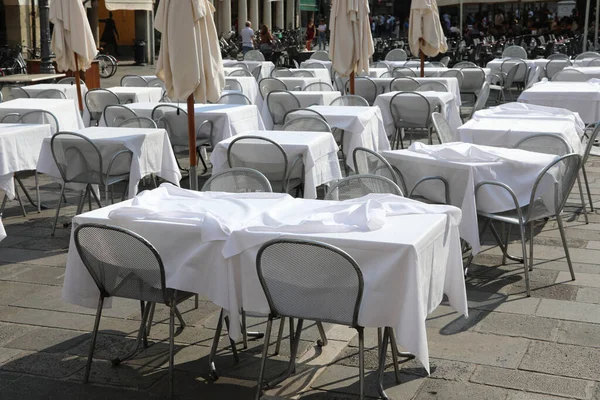 欧州都市広場のコロナウイルスのロックダウンによって引き起こされる経済危機の間に広場の屋外バーで顧客なしの空の椅子とテーブル — ストック写真