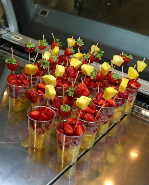 夏のトロピカルビーチバーで販売するために イチゴとパイナップルスライスをガラスの中に入れた新鮮な塊状の果物の串焼き — ストック写真