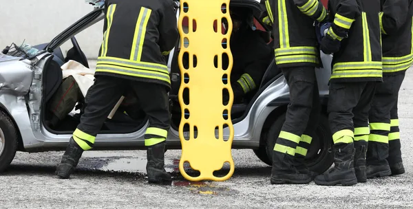 車の事故後の勇敢な消防団と黄色のストレッチャー — ストック写真