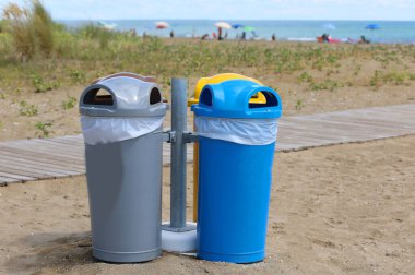 Yaz tatilinde kumsalda geri dönüşümlü atıkların geri dönüşümü için dört kutu.