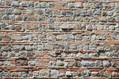 Duvarın arka planında bir sürü tuğla ve taştan yapılmış bir ev harcı ve çimento var.