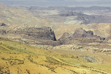 Orta Doğu 'daki kumlu çöl arazisinden çıkan kayaların hava manzarası.
