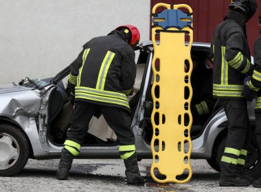 Yaralıları taşımak için sedyeyle yapılan kazadan sonra itfaiyeciler olay yerinde.