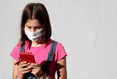 Arkadaşlarına mesaj atmak için akıllı telefonu kullanan tatlı küçük kız.