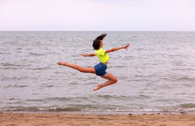 BICHE adlı geyiğin büyük sıçrayışı yazın deniz kenarındaki atletik kız tarafından mükemmel bir şekilde gerçekleştirildi.