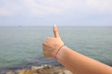 Olumluluğun deniz sembolü genç elin başparmağı ve her şey yolunda.